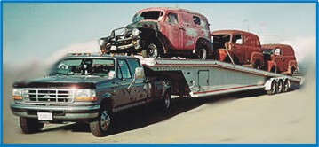 Picture of trailer  loaded with  panel trucks and Ford parts 